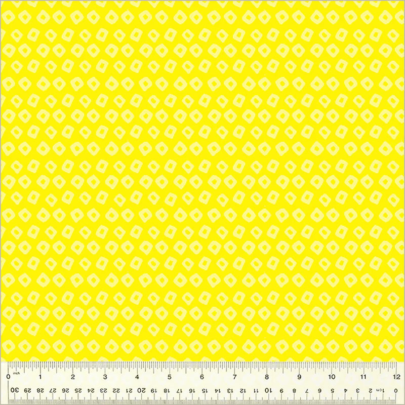 Yellow fabric with a geometric pattern and a ruler at the bottom for scale.