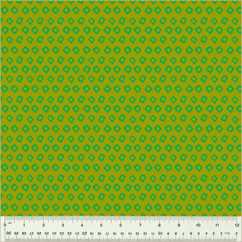 Green fabric with a geometric pattern and a ruler at the bottom for scale.