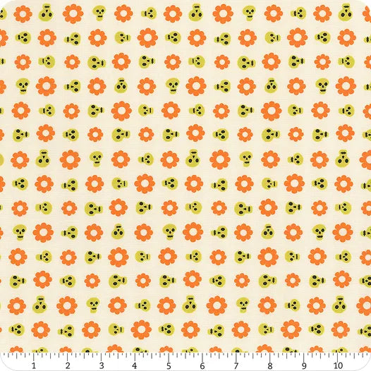 Pattern of orange flowers and yellow skulls on a beige background with a ruler at the bottom.