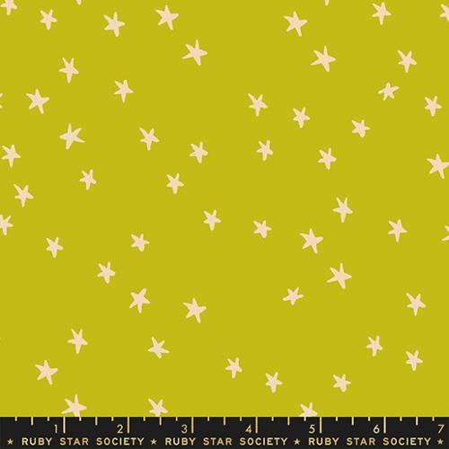 Fabric with star pattern on a green background, featuring a ruler at the bottom.